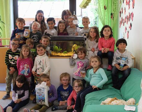 Gemeinsam mit ihren Erzieherinnen Julia Waldhauser (hinten l.) und Martina Dolles (hinten r.) haben die Kinder der Marienkäfergruppe des St. Wolfgang-Kindergartes in ihrem Gruppenzimmer ein Aquarium eingerichtet. Die Kleinen kümmern sich zuverlässig um das Wohlergehen der Fische. - Foto von Werner Schulz