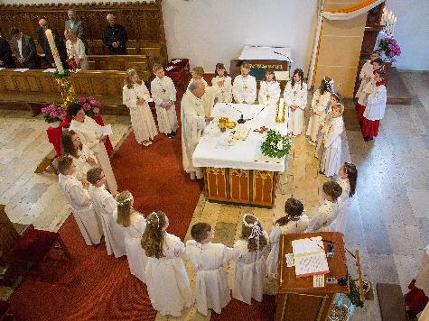 Höhepunkt des Festgottesdienstes war der feierliche Empfang der Heiligen Kommunion. Dazu versammelten sich die 20 Erstkommunikanten mit Stadtpfarrer Hans-Peter Bergmann und Gemeindereferentin Barbara Schlosser um den Volksaltar. - Foto von Werner Schulz