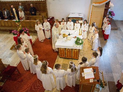 Höhepunkt des Festgottesdienstes war der feierliche Empfang der Heiligen Kommunion. Dazu versammelten sich die 20 Erstkommunikanten mit Stadtpfarrer Hans-Peter Bergmann und Gemeindereferentin Barbara Schlosser um den Volksaltar. - Foto von Werner Schulz