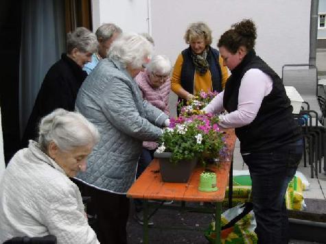 Ganze Arbeit leisteten die Gäste der solitären Tagespflege beim Bepflanzen der Balkonkästen für die Terrasse des Hauses. Die Blumen- und Kräuterpflanzen hatte der Blumenladen Floristik Epp gespendet, wofür sich Tagespflegeleiterin Birgit Seidl (2.v.r.) herzlich bedankte. - Foto von Werner Schulz