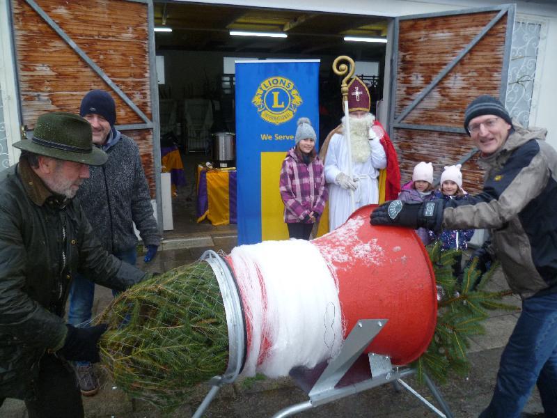 Bei ungemütlichem Schneeregen hatten die Lions-Mitglied beim Verpacken der Blaufichten und Nordmanntannen alle Hände voll zu tun. Für die Kinder hatte der Nikolaus kleine Geschenke dabei. Bild: Uschald - Foto von Uschald