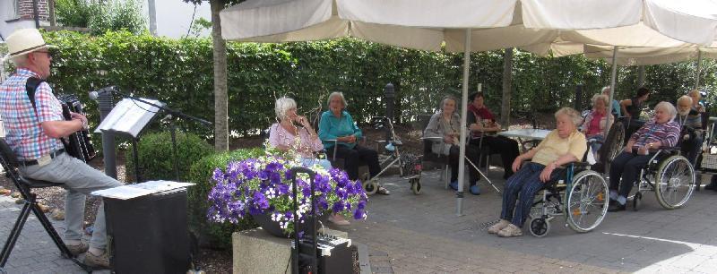 Seit Ausbruch der Corona-Pandemie mussten die Bewohner*innen des Seniorenheims Evergreen auf ihr ge- und beliebtes Wunschkonzert verzichten. Letzten Freitag konnte der „Tschörmän“ (l.) - wie die Senior*innen German Adam nennen – erstmals wieder auf der Heimterrasse mit seiner Ziehharmonika ihre Musikwünsche erfüllen. - Foto von Werner Schulz