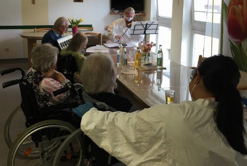 Nach von der Corona-Pandemie erzwungener, monatelanger Pause konnte Birgit Seidl (stehend r.), die Leiterin der Solitären Tagespflege St. Barbara, ihre Pflegegäste erstmals wieder zu einem Musiknachmittag einladen. Gestaltet wurde dieser von der Klangbrettgruppe der Caritas-Sozialstation und dem Chorsänger Alois Schießl. - Foto von Werner Schulz