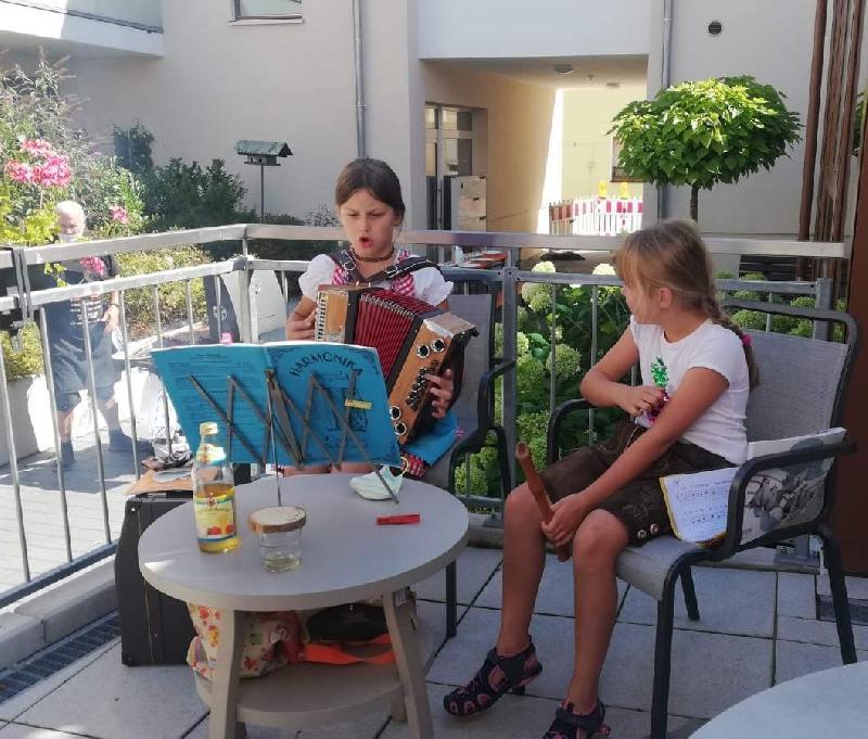 Auf Initiative von Tagespflegeleiterin Birgit Seidl feierten die Tagespflegegäste gemeinsam mit Bewohnern des gegenüber liegenden Hauses Conrad ein Grillfest. Für das i-Tüpfelchen sorgten mit ihren beschwingten Musikstücken die 9-jährige Hannah mit ihrer Ziehharmonika und die 6-jährige Lotta auf ihrer Blockflöte - Foto von Werner Schulz