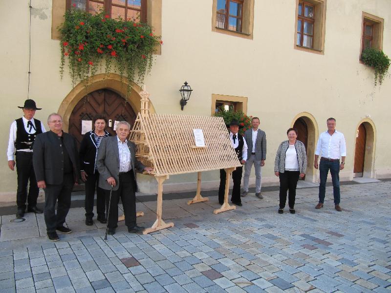 Bild: Von links  Hinter dieser Eingangstür des Hirschauer Rathauses steht das Dachstuhlmodell ab sofort. Karl Müller, er betreut die Projekte, Manfred Reiß, Vorsitzender des Heimatvereins Parkstein, Maria Hauer ihr Mann Zimmerermeister Josef Hauer; rechts neben dem Modell Josef Donhauser, Vorsitzender des Vereins der Zimmerer und Schreiner Amberg, 3. Bürgermeister Hermann Gebhard, 2. Bürgermeisterin Bärbel Birner, Erster Bürgermeister Hermann Falk - Foto von Gerhard Fleischmann