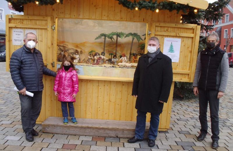 Ab heute erinnert auf dem Hirschauer Marktplatz eine in einem Markthäuschen ausgestellte Krippe mit den „Regensburger Bibelfiguren“ daran, dass Weihnachtszeit ist. Die Idee dazu hatte Günther Siegert (r.), der 1. Vorsitzende der Elterninitiative Eltern für Kinder e.V., der alljährlich den Weihnachtsmarkt organisiert. Unterstützt wurde er von Martin Merkl (2.v.r.), der für die alljährliche Krippenausstellung verantwortlich zeichnet. Zur Verfügung gestellt haben die Figuren Bärbel und Reinhold Birner (l.) mit seiner Enkelin Mathilda. - Foto von Werner Schulz