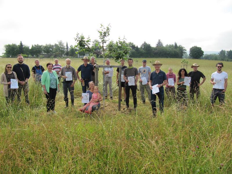 Die Baumpaten erhielten die Urkunden in der Streuobstwiese von 2.Bürgermeisterin Bärbel Birner (vierte v. links). Die Leitung des Projekt liegt bei OGV Vorsitzendem Roland Maier (5. v rechts). Er wurde beim Johannischnitt fachlich unterstützt durch Eduard Eckl (7. v. links) - Foto von Gerhard Fleischmann