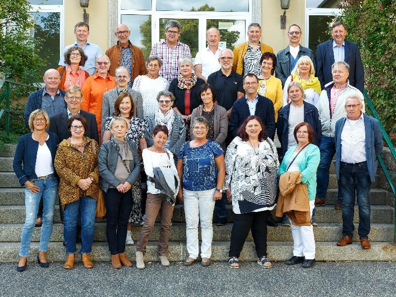 Anlässlich ihres 60. Geburtstags gab es für die Angehörigen des Schülerjahrgangs 1960/61 ein Wiedersehen beim Klassentreffen. Organisiert hatten es Erwin Zach (vorne r.) und Ingrid Ströhl (3. Reihe, 4. V. l.). Sie konnten 42 Klassenkamerad*innen begrüßen, 31 davon kamen zum Fototermin auf der Schulhaustreppe. - Foto von Werner Schulz