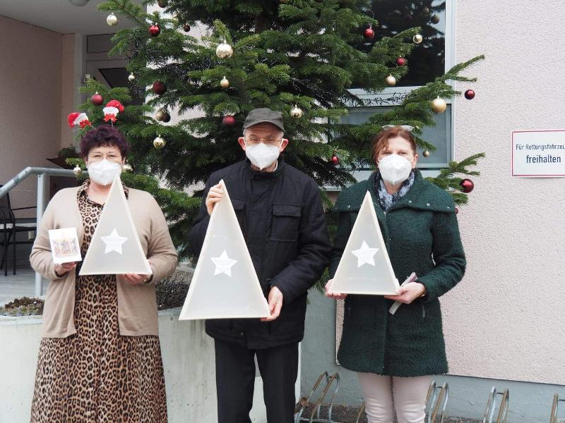 Da die traditionelle Senioren-Adventfeier wegen der Corona-Pandemie ausfallen musste, fertigten die PGR-Mitglieder 150 leuchtende Christbäumchen, die den Senior*innen nach Hause gebracht wurden. 77 davon überreichten Stadtpfarrer Johann Hofmann (Mitte) und Beate Dietrich (r.) an BRK-Seniorenheimleiterin Astrid Geitner (l). - Foto von Werner Schulz