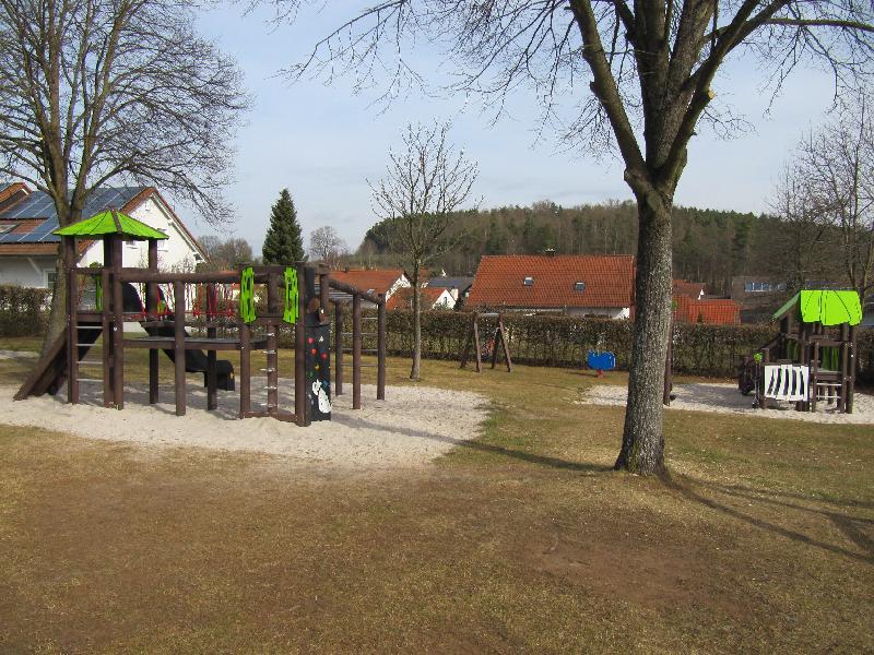 Eine Hecke begrenzt derzeit den Spielplatzbereich an der Lessing/Schillerstraße. Die Fläche hinter der Hecke könnte noch dazu kommen.
 - Foto von Gerhard Fleischmann