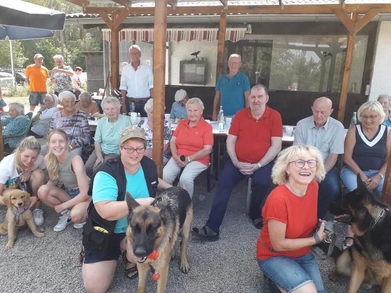 Nicht nur die Gäste der Solitären Tagespflege St. Barbara, auch Bürgermeister Hermann Falk (stehend hinten l.) und der Seniorenbeauftragte Stadtrat Rudi Wild (stehend hinten r.) waren von ihrem Besuch auf dem Übungsplatz des Hundesportvereins beeindruckt. Vorne kniend v. l.: Hundebesitzerinnen Beate Ries (mit Hund Kuno) und Maria Kammerer (mit Hund Rambo). - Foto von Werner Schulz