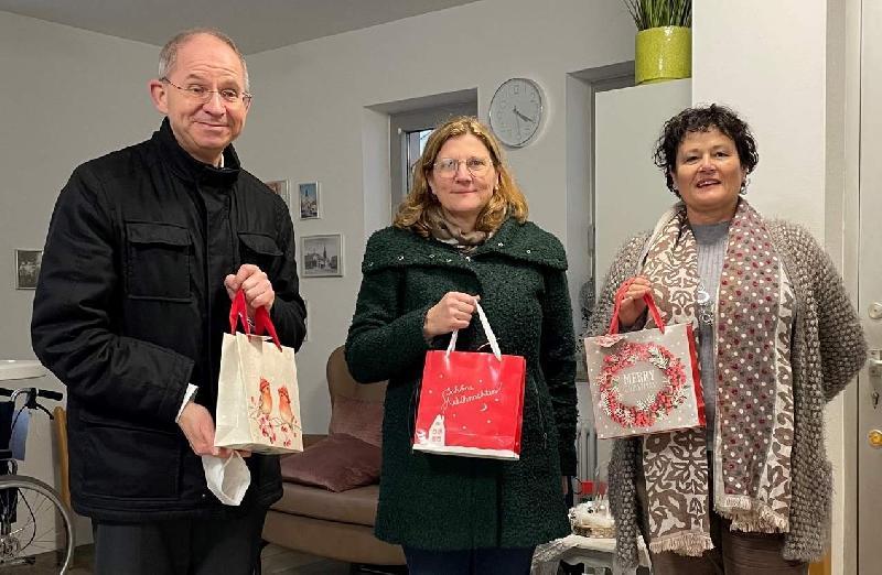 Stadtpfarrer Johann Hofmann (l.) und PGR-Sprecherin Beate Dietrich (Mitte) überreichten Heimleiterin Astrid Geitner (r.) als Weihnachtspräsent für die Heimbewohner*innen eine mit Pflegemitteln gefüllte Tüte. - Foto von Werner Schulz