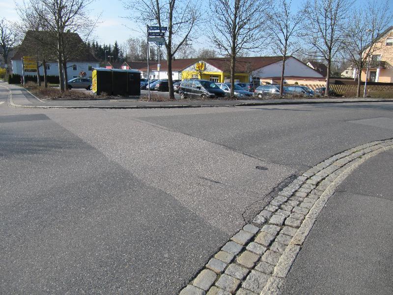 Recht holprig stellt sich der Straßenübergang zwischen dem Kriegerdenkmal und dem Nettomarkt dar. Besonders für Menschen mit Rollatoren oder Kinderwägen brächte die Absenkung der Bordsteine  neine deutliche Verbesserung. - Foto von Gerhard Fleischmann