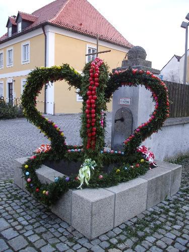 Seit vergangener Woche schmückt ein liebevoll gestalteter Osterbrunnen den Bischof-Bösl-Platz nördlich der Stadtpfarrkirche Mariä Himmelfahrt. - Foto von Werner Schulz