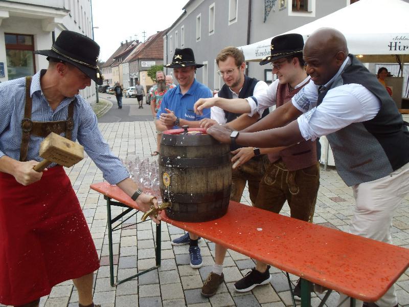 Pünktlich um 17 Uhr zapfte LtC Matthews Piosa (l.) in Profimanier mit einem einzigen Holzhammerschlag das erste Fass Festbier aus der heimischen Schlossbrauerei und verkündete in fast astreinem Bayerisch, dass „o’zapft is“. Ihm assistierten v. r.: Colonel Kevin Poole, Brauerei-Chef Sebastian Dorfner, 2. Musikzugvorst. Erik Remhof und Vorstand Maximilian Stein. - Foto von Werner Schulz