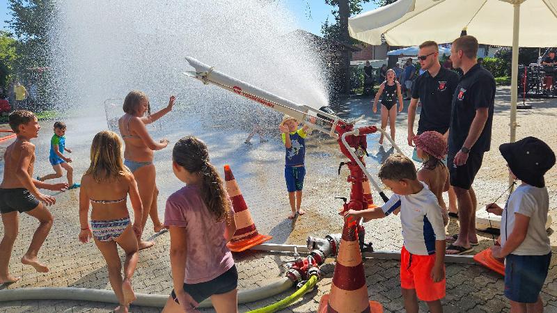 Heiß begehrt war bei den Kindern das Spritzen mit dem großen Wasserwerfer. Bis zu 80 Meter weit könnte man mit ihm spritzen. Auf Sprühstrahl eingestellt sorgte er für einen mächtigen Sprühnebel, der angesichts der hohen Temperaturen für eine sehr willkommene Erfrischung sorgte. Mit im Bild die beiden Aufsichten Marco Schuminetz (r.) und Florian Pawluk (l.). - Foto von Werner Schulz