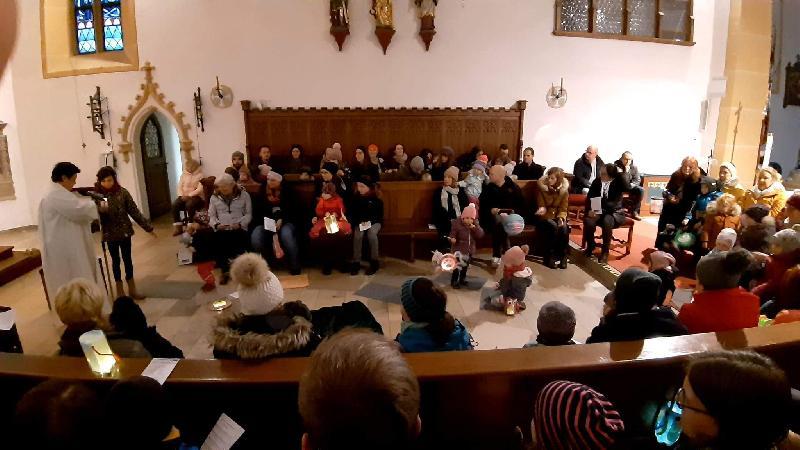 Rappelvoll war der Altarraum der katholischen Stadtpfarrkirche, als gut 30 Kleinkinder mit ihren Familien den Namenstag des Heiligen Martin feierten, die von Gemeindereferentin Barbara Schlosser (stehend l.) und EKG-Leiterin Lisamarie Schmidl gestaltet wurde. - Foto von Werner Schulz