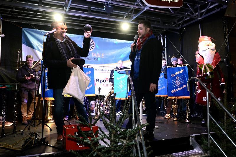 Andreas Diehl und Sebastian Fuchs sorgen als Versteigerung für Unterhaltung auf der Bühne des Christkindlmarkts. Neben den beiden städtischen Bäumen kommen auch andere Sachen unter den Hammer. Bild a: M. Golinski Bild b: Uschald - Foto von Uschald