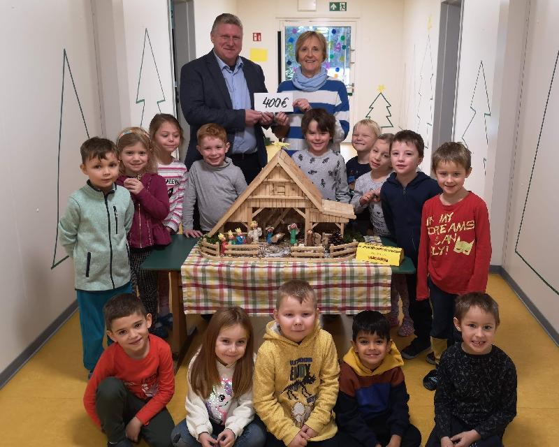 Mit seiner von Stadtrat Martin Merkl organisierten Krippenausstellung erzielte der CSU-Ortsverband heuer einen Erlös von 400 Euro. Den entsprechenden Scheck übergab Merkl (hinten l.) im Beisein der Kindergruppe, die ihre Knetmassenkrippe (Bildmitte) ausgestellt hatte, an KiGa-Leiterin Evelyn Högl (hinten r.). - Foto von Werner Schulz