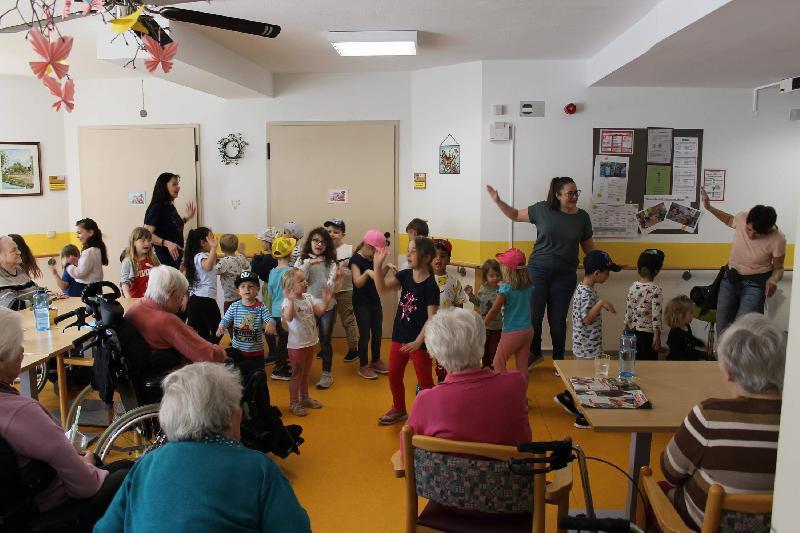 Mit fröhlichen Tanzliedern brachten die Krippen- und Kindergartenkinder des Marien-Kindergartens den Bewohnern des BRK Seniorenwohn- und Pflegeheims den Frühling ins Haus. Vorne links: Kita-Leiterin Christa Bauer, Mitte Erzieherin Simone Heidl, rechts Kinderpflegerin Gisela Falk. - Foto von Werner Schulz