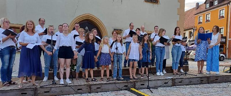 Die „Herzwärts-Kinder“ unter Leitung von Gertrud Siegert (vorne 2. von links) rührten mit ihren Darbietungen die Herzen der knapp 400 Zuschauer. Die „Happy Voices“ unter Leitung von Andrea Eichenseer (hinten 4. von links) taten mit ihren „fröhlichen Stimmen“ das Ihrige dazu, dass auf dem Markplatz „Summerfeeling pur“ herrschte. - Foto von Werner Schulz