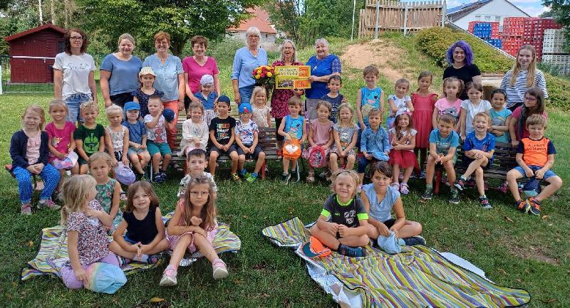 Bei der Mittsommer-Serenade des Gemischten Chors hatten die Kinder des St. Wolfgang-Kindergartens das Publikum mit ihrem tollen Auftritt begeistert. Als Dankeschön überreichten die Gesangvereinsvorsitzende Renée Ehringer-Hoffmann (hinten 3. von rechts) und Brigitte Schwarz (hinten 5. von rechts) an KiTa-Leiterin Uta-Maria Kriegler (hinten 4. von rechts) unter dem Jubel der Kinder einen 150-Euro-Scheck. - Foto von Werner Schulz