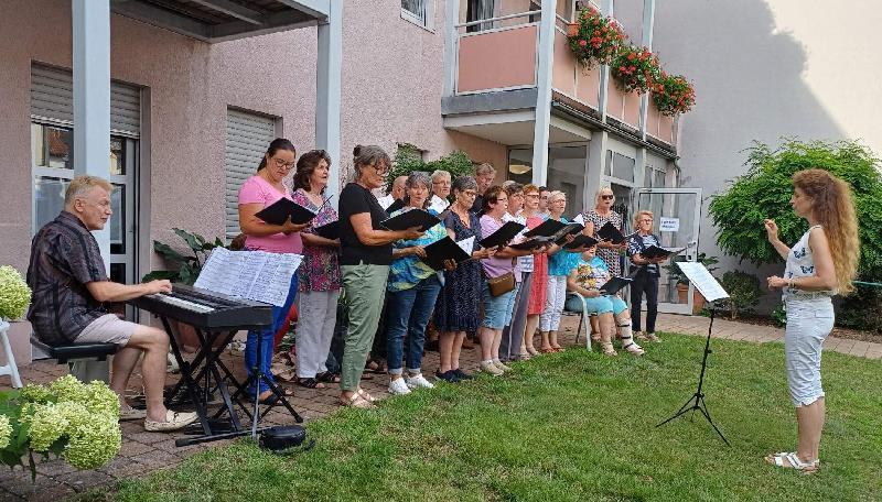 Mit seiner Serenade bereitete der Gemischte Chor unter Leitung von Jana Müller (vorne r.) den Bewohnern des BRK Seniorenwohn- und Pflegeheims St. Barbara und den zahlreichen Gästen einen gleichermaßen stimmungsvollen wie kurzweiligen Abend. Links am E-Piano Roman Podokschik. - Foto von Werner Schulz