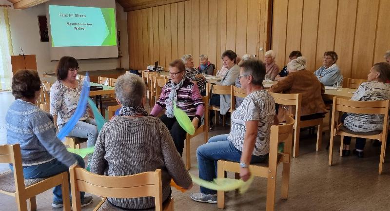 Tagespflegeleiterin Kati Köhler beschränkte ihren Info-Besuch im Seniorentreff nicht auf theoretische Aussagen. Sie lud die Besucherinnen z.B. ein, im Sitzen gemeinsam mit ihr einen mexikanischen Walzer zu tanzen. - Foto von Werner Schulz