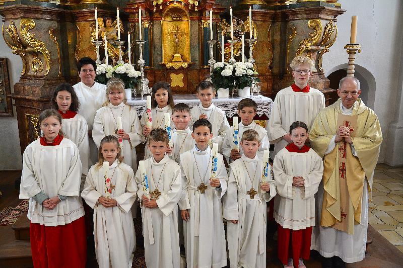 Neun Kinder, drei Mädchen und sechs Buben, feierten in der Pfarrkirche St. Michael ihre Erstkommunion. Re. Pfarrer Johann Hfmann, li. hinten Gemeindereferentin Barbara Schlosser. - Foto von Fritz Dietl.