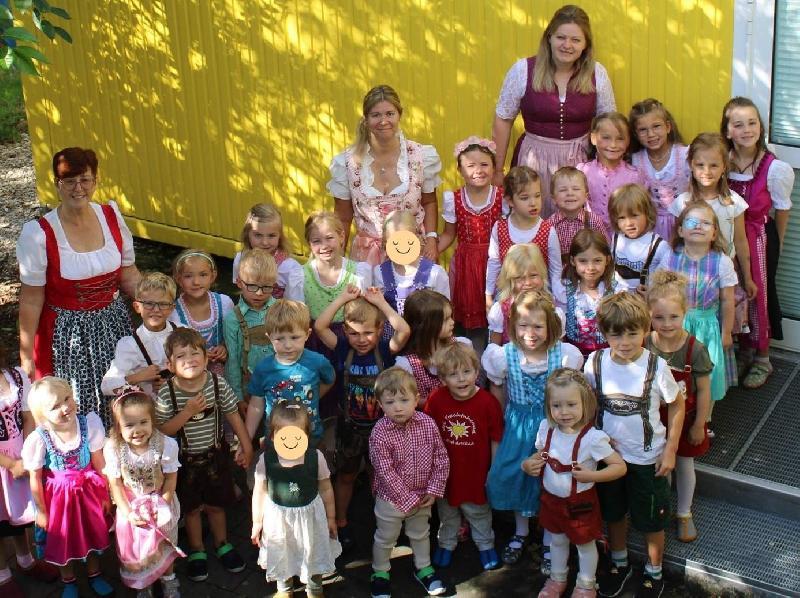 Zum „Tag der Tracht“ kamen viele Mädchen und Buben des St. Wolfgang-Kindergarten in Lederhosen oder im Dirndl in den Kindergarten. Das taten auch die stellvertretende Leiterin Katrin Noßner (hinten Mitte) sowie die Erzieherinnen Martina Dolles (links) und Nicole Korent (rechts). - Foto von Werner Schulz