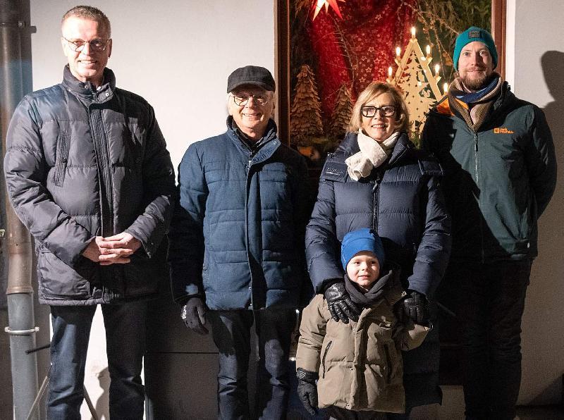 Bürgermeister Hermann Falk (links) öffnete am Montag das erste Türchen des 23. Lebendigen Adventskalenders. Er dankte allen, die zum Gelingen der Veranstaltungsreihe beitragen. Dies taten auch der Gewerbeverbandsvorsitzende Alfred Härtl (2. von links) und der Trachtenvereinsvorsitzende Michael Meier (rechts). Petra Waldhauser (2. von rechts mit Enkel Leo), die Vorsitzende der Selbsthilfegruppe krebskranker Kinder, dankte dafür, dass ihr Verein heuer als Spendenempfänger ausgewählt wurde. - Foto von Alfred Härtl