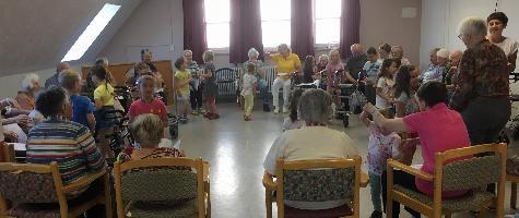 Kinder und Senioren haben Spaß am gemeinsamen Singen und Tanzen